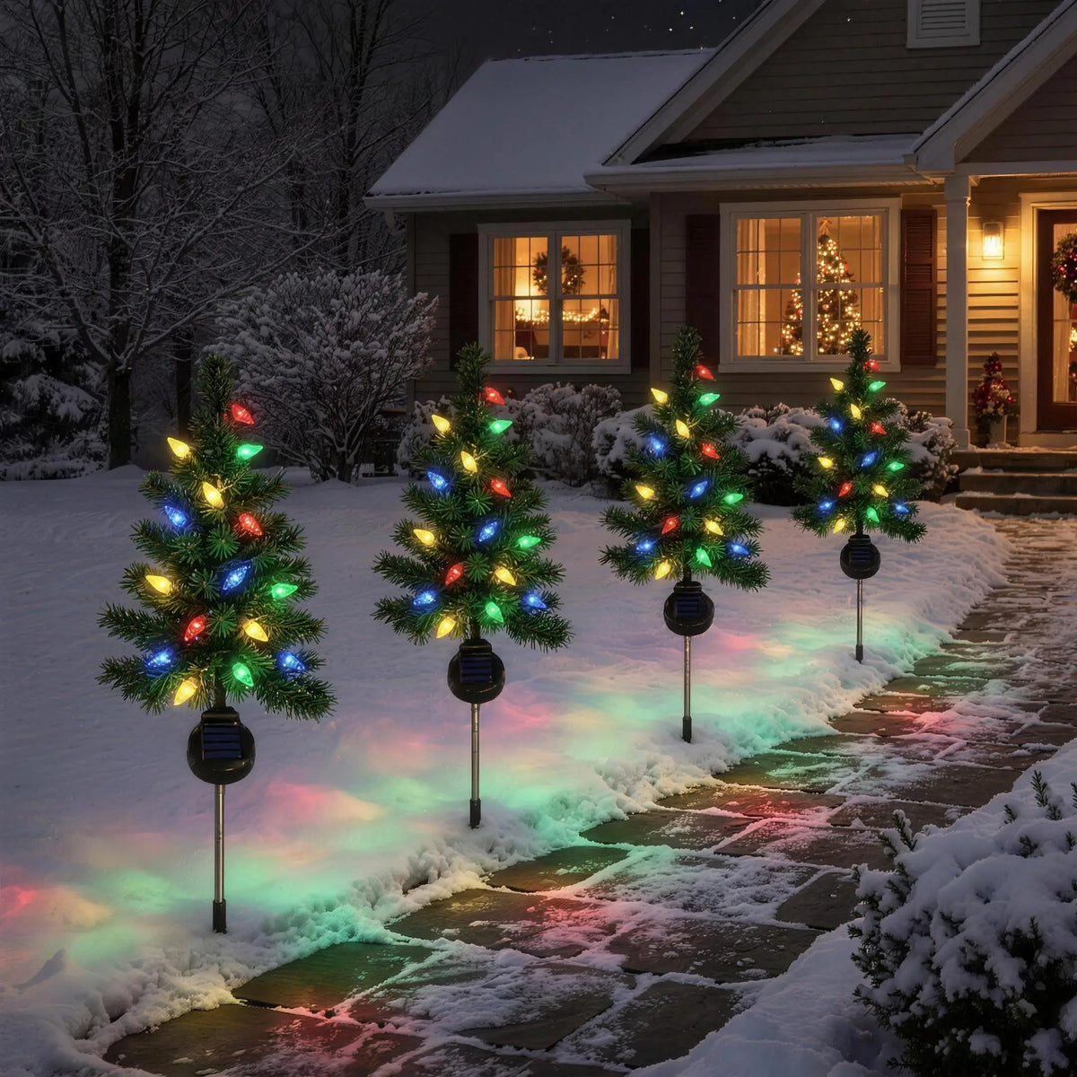 Solar Christmas trees along a front walkway at night