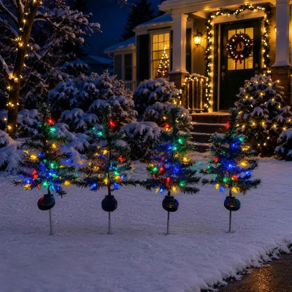 Solar Christmas trees lighting a snowy front yard