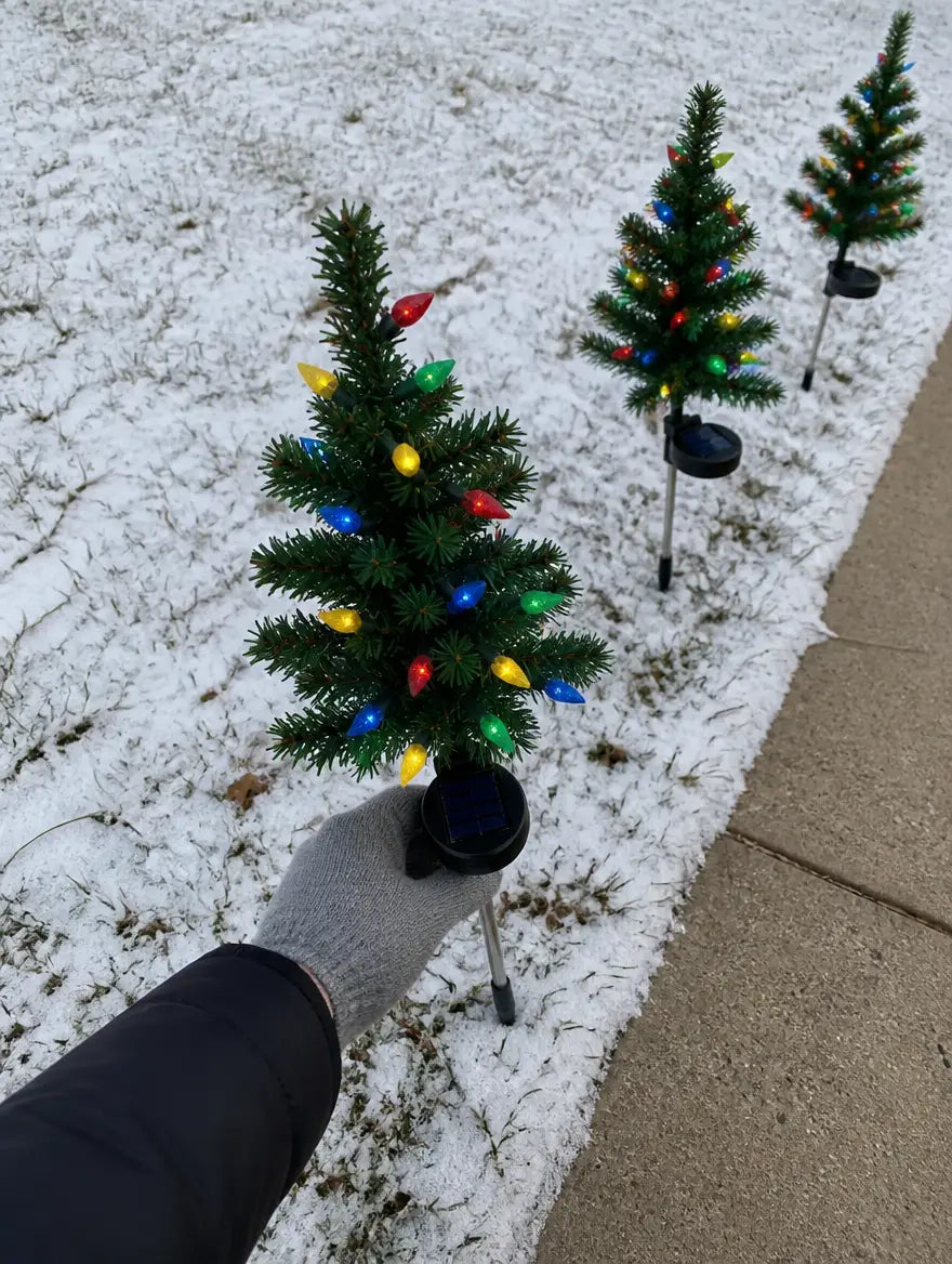 Pushing a SolarNoel tree into the snowy lawn